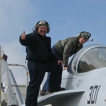 A pilot with his thumbs up while climbing aboard